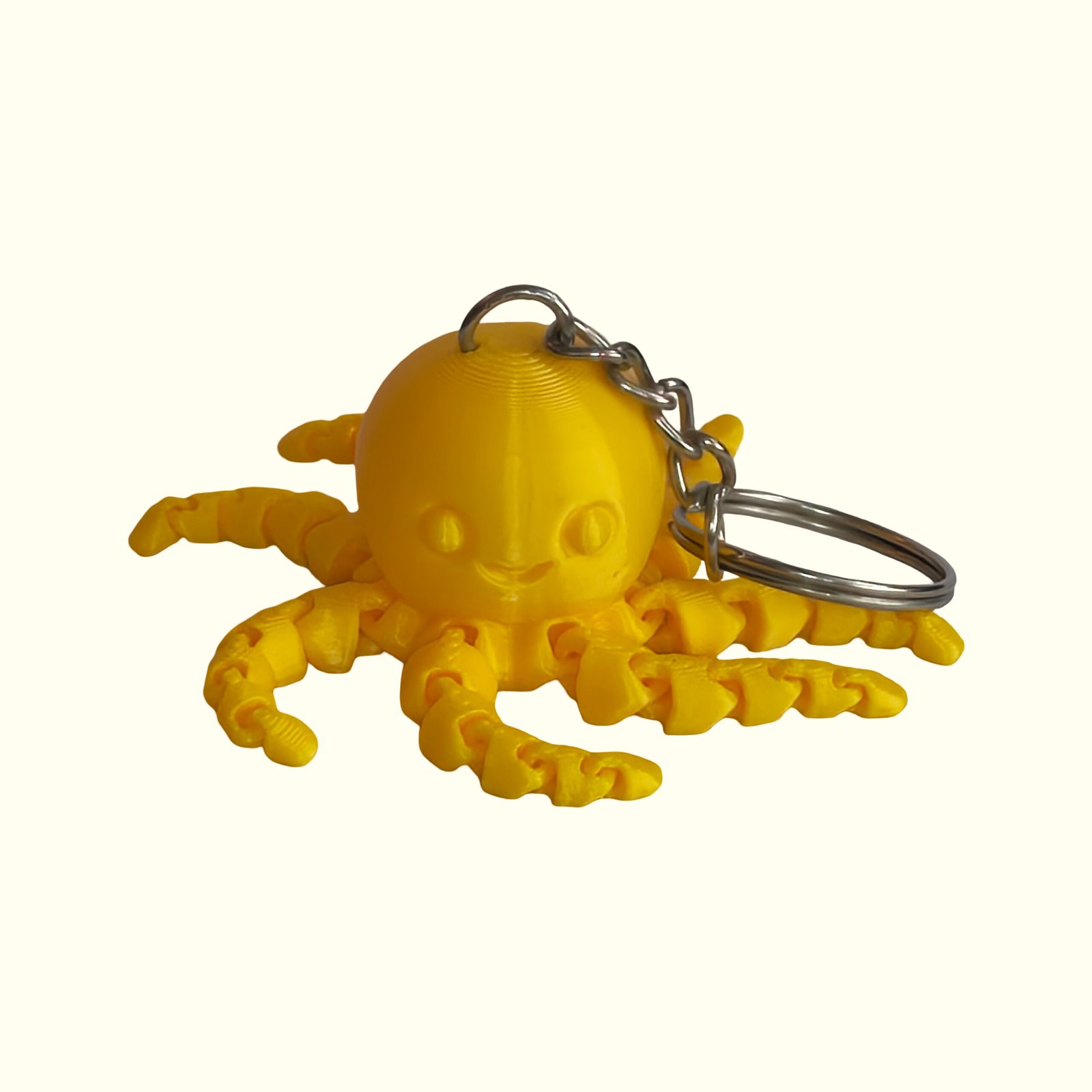 3D printed articulated octopus keychains in yellow and magenta with moving tentacles and silver keyrings