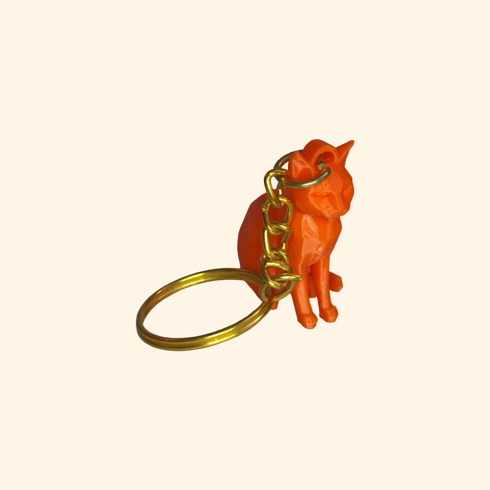 3D printed low poly sitting cat keychains in yellow, magenta, orange and green with sculpted detail